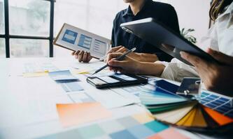 Close up ux developer and ui designer brainstorming about mobile app interface wireframe design on table with customer breif and color code at modern office.Creative digital development agency photo