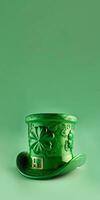 3D Render of Clover Leaves Printed Leprechaun Hat On Green Background. St. Patrick's Day Concept. photo