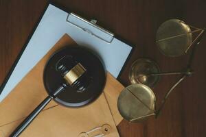 Business and lawyers discussing contract papers with brass scale on desk in office. Law, legal services, advice, justice and law concept picture with film grain effect photo