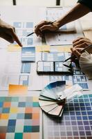 Close up ux developer and ui designer brainstorming about mobile app interface wireframe design on table with customer breif and color code at modern office.Creative digital development agency photo