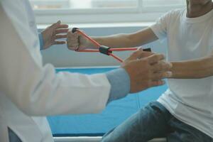 Doctor or physical therapist examines back pain and spinal area to give advice within the rehabilitation center. photo