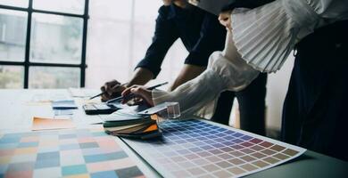 Close up ux developer and ui designer brainstorming about mobile app interface wireframe design on table with customer breif and color code at modern office.Creative digital development agency photo