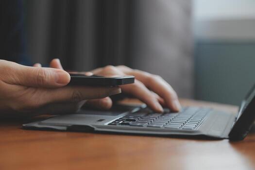Asian Businesswoman Using laptop computer and working at office with calculator document on desk, doing planning analyzing the financial report, business plan investment, finance analysis concept. photo