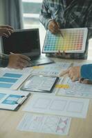 Close up ux developer and ui designer brainstorming about mobile app interface wireframe design on table with customer breif and color code at modern office.Creative digital development agency photo