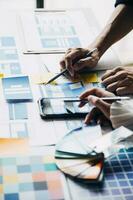 Close up ux developer and ui designer brainstorming about mobile app interface wireframe design on table with customer breif and color code at modern office.Creative digital development agency photo