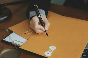 Business and lawyers discussing contract papers with brass scale on desk in office. Law, legal services, advice, justice and law concept picture with film grain effect photo