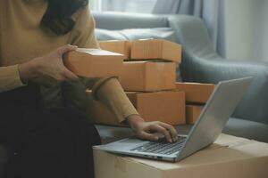 Business woman start up small business entrepreneur SME success .freelance woman working at home with Online Parcel delivery. SME and packaging deliveryconcept photo