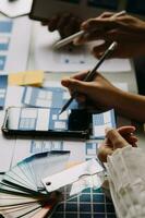 Close up ux developer and ui designer brainstorming about mobile app interface wireframe design on table with customer breif and color code at modern office.Creative digital development agency photo