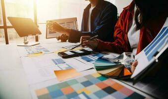 Close up ux developer and ui designer brainstorming about mobile app interface wireframe design on table with customer breif and color code at modern office.Creative digital development agency photo