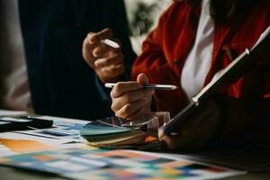 Close up ux developer and ui designer brainstorming about mobile app interface wireframe design on table with customer breif and color code at modern office.Creative digital development agency photo