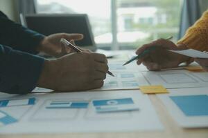 Close up ux developer and ui designer brainstorming about mobile app interface wireframe design on table with customer breif and color code at modern office.Creative digital development agency photo