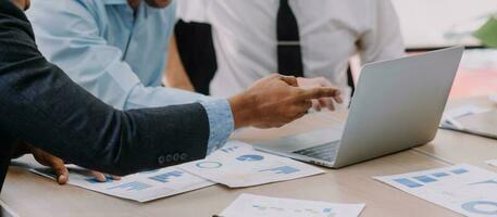 Financial analysts analyze business financial reports on a digital tablet planning investment project during a discussion at a meeting of corporate showing the results of their successful teamwork. photo