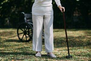 young asian physical therapist working with senior woman on walking with a walker photo