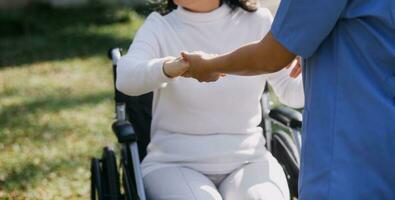 young asian physical therapist working with senior woman on walking with a walker photo