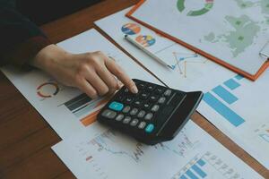 Group of confident business people point to graphs and charts to analyze market data, balance sheet, account, net profit to plan new sales strategies to increase production capacity. photo