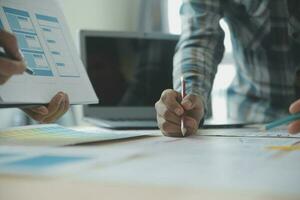 Close up ux developer and ui designer brainstorming about mobile app interface wireframe design on table with customer breif and color code at modern office.Creative digital development agency photo