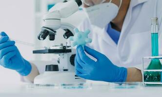 hand of scientist with test tube and flask in medical chemistry lab blue banner background photo