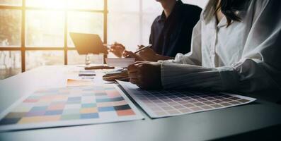 Close up ux developer and ui designer brainstorming about mobile app interface wireframe design on table with customer breif and color code at modern office.Creative digital development agency photo