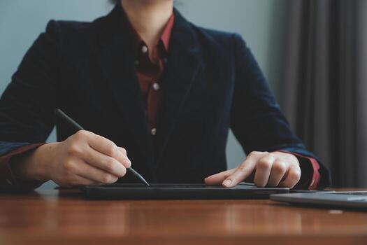 Asian Businesswoman Using laptop computer and working at office with calculator document on desk, doing planning analyzing the financial report, business plan investment, finance analysis concept. photo