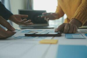 Close up ux developer and ui designer brainstorming about mobile app interface wireframe design on table with customer breif and color code at modern office.Creative digital development agency photo