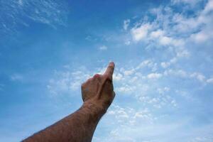 hand up gesturing in the blue sky, feelings and emotions photo