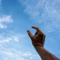 hand up gesturing in the blue sky, feelings and emotions photo