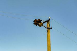 Power electric pole with line wire on colored background close up photo