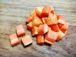 Diced carrots on wooden cutting board. photo