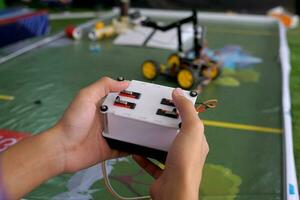 Asian high school students practice moving robots on the playing field To perform missions according to the rules of the robot competition. Soft and selective focus. photo