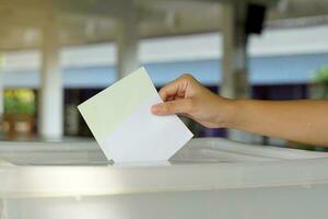 tailandés personas emitir su votación documentos dentro el caja a votar para miembros de el casa de representantes, utilizando elección en un distrito electoral base y lista de fiestas proporcional representación. foto