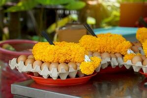 Eggs, marigold flower garlands and sticks of incense sticks are placed on trays to be offered as offerings to sacred objects when the request is fulfilled, which is the belief of some Asians. photo