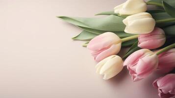 Pink and white tulips arranged diagonally on a shell pink background with copy space. . photo