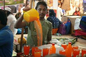 7th April 2023, Zakaria Street, Kolkata, West Bengal, India. Young aged boy selling refreshing drinks  at Zakaria Street During Ramjan month photo