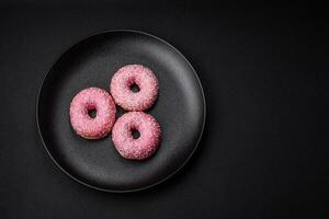 Delicious fresh sweet donuts in pink glaze with strawberry filling photo