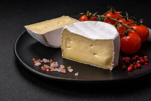 Delicious fresh brie cheese in the form of a mini head with cherry tomatoes photo