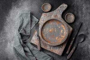 Empty wooden plate, knife, fork and cutting board photo