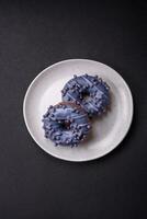 Delicious sweet donut of purple color in glaze and with lilac balls photo