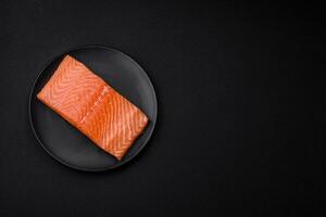 Fresh raw salmon red fish fillet with salt and spices photo