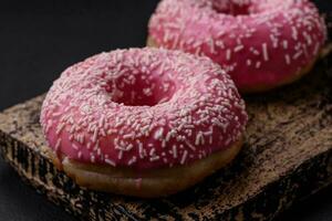 Delicious fresh sweet donuts in pink glaze with strawberry filling photo