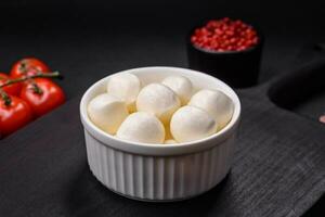 Delicious fresh mozzarella cheese in the form of small balls with salt and spices photo
