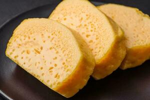 delicioso poroso amarillo queso cortar en grande piezas en un cerámico plato foto