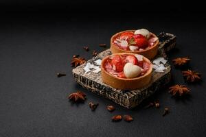 Delicious fresh sweet tartlets with strawberries and coconut flakes photo