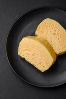 Delicious porous yellow cheese cut in large pieces on a ceramic plate photo