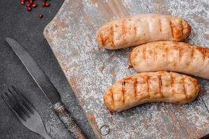 Delicious grilled sausages from chicken or pork meat with salt, spices and herbs photo