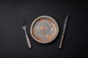 Empty wooden plate, knife, fork and cutting board photo