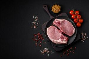 Raw pork on the bone or rib sliced with salt, spices and herbs photo