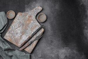 Knife, fork and cutting board, salt, pepper and other ingredients photo