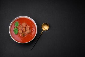 delicioso Fresco gazpacho con migas de pan, sal y especias en un cerámico plato foto