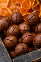 Delicious roasted macadamia nuts in shell on a dark textured background photo
