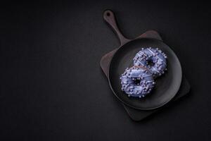 Delicious sweet donut of purple color in glaze and with lilac balls photo